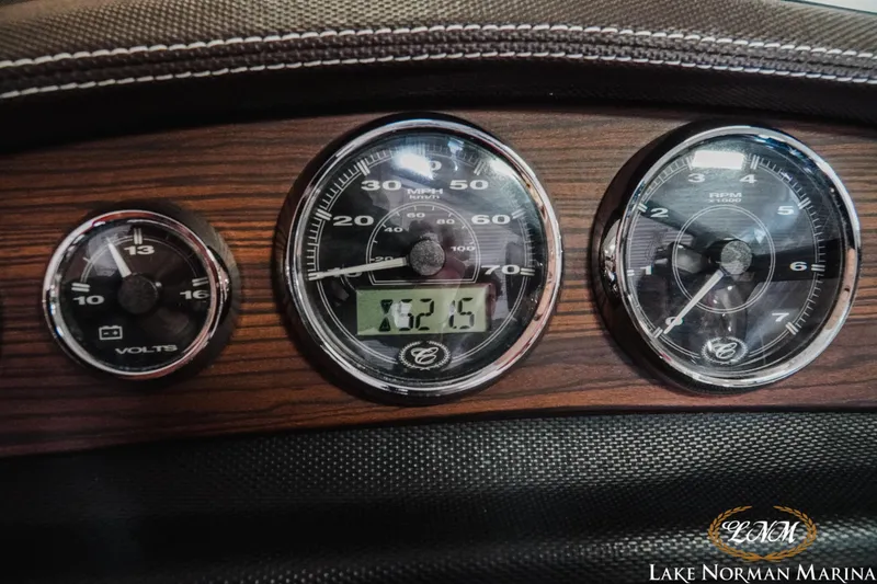 Slide: The Image of Dashboard of a 2013 Cobalt 232 boat with gauges and wood finish. - 16