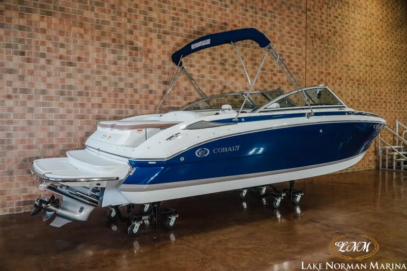 Slide: The Image of 2013 Cobalt 232 boat with blue and white design at Lake Norman Marina. - 2
