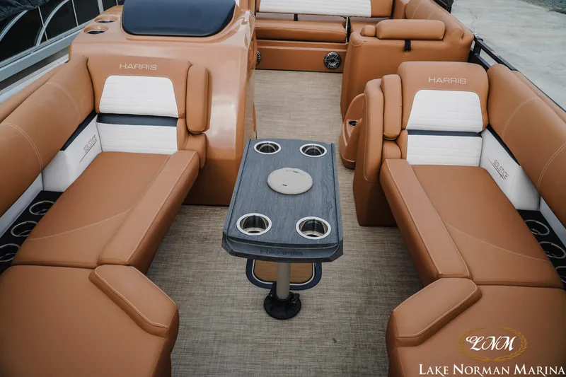 Slide: The Image of 2023 Harris FloteBote 230 Solstice interior with tan seating and central table. - 13