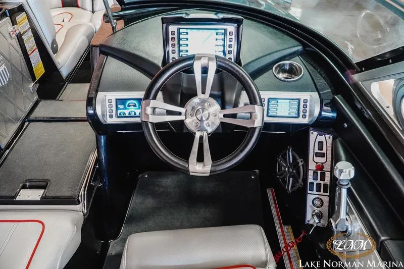 Slide: The Image of 2014 MasterCraft X-Star boat dashboard with steering wheel and digital controls. - 12