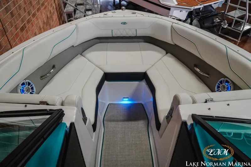 Slide: The Image of 2022 Regal LS2 Surf boat interior with white seating and blue LED lighting. - 13