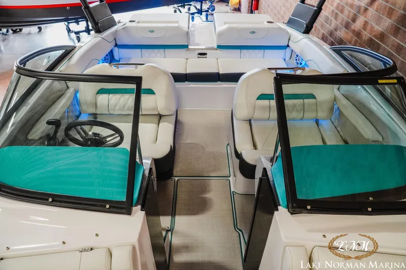 Slide: The Image of 2022 Regal LS2 Surf boat interior with teal and white seating, showcased at Lake Norman Marina. - 15