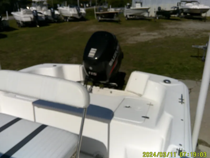 Slide: The Image of 2012 Carolina Skiff 198 DLV boat with outboard motor, parked in a marina. - 10