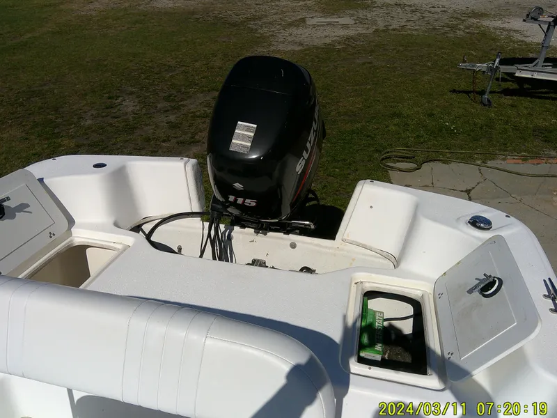 Slide: The Image of 2012 Carolina Skiff 198 DLV boat with outboard motor, parked on grass. - 11