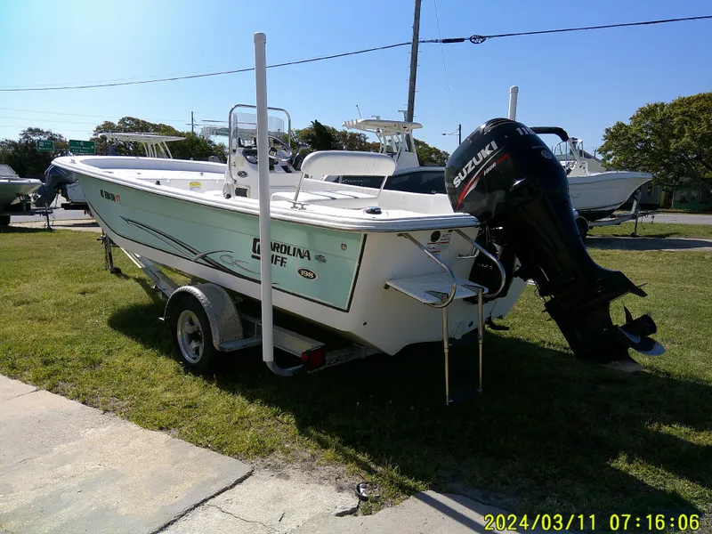 Slide: The Image of 2012 Carolina Skiff 198 DLV boat on trailer with Suzuki outboard motor. - 2
