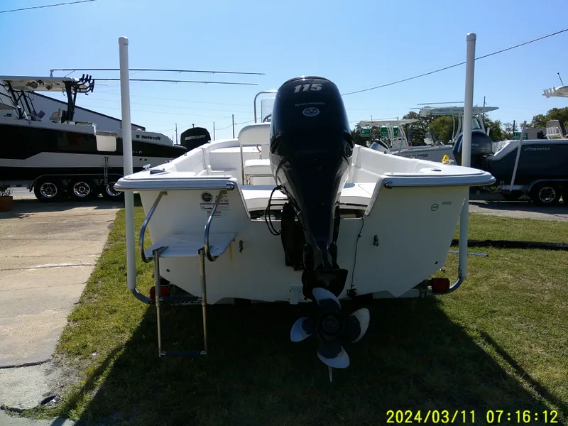 Slide: The Image of 2012 Carolina Skiff 198 DLV boat with outboard motor, parked on grass. - 3
