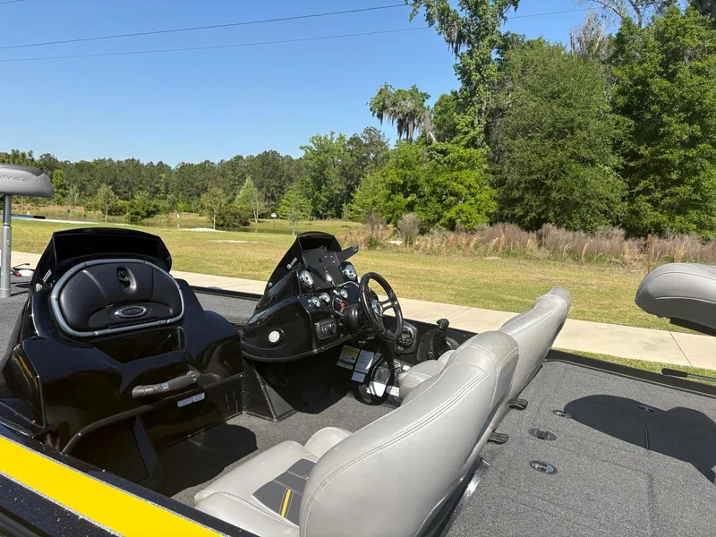 Slide: The Image of 2017 Nitro Z19 boat interior with steering wheel and seats, set in a scenic outdoor location. - 2