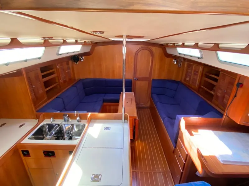 Slide: The Image of Interior of 2000 J Boats J/46 sailboat with wood finish and blue seating. - 16