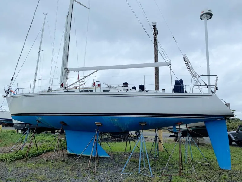 Slide: The Image of 2000 J Boats J/46 sailboat on stands, displayed outdoors under cloudy skies. - 28