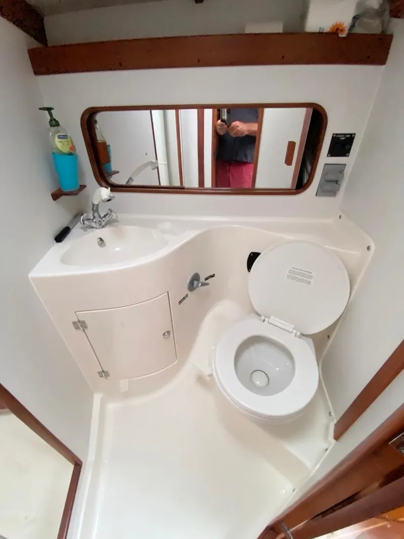 Slide: The Image of Bathroom interior of a 2000 J Boats J/46 yacht, featuring a compact sink and toilet. - 30
