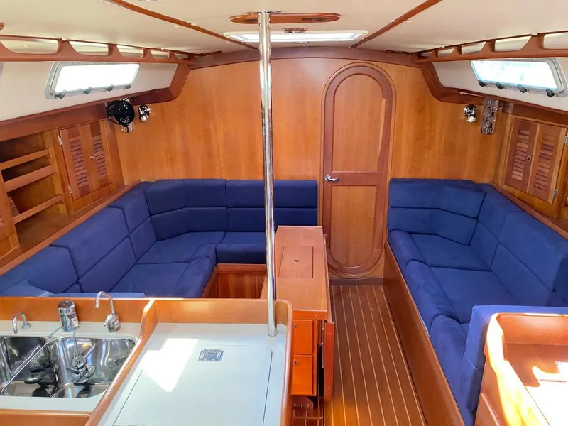 Slide: The Image of Interior of 2000 J Boats J/46 sailboat with blue seating and wooden finishes. - 31