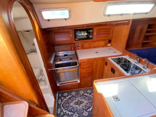 Slide: The Image of Interior of 2000 J Boats J/46 yacht featuring kitchen and wooden cabinetry. - 34