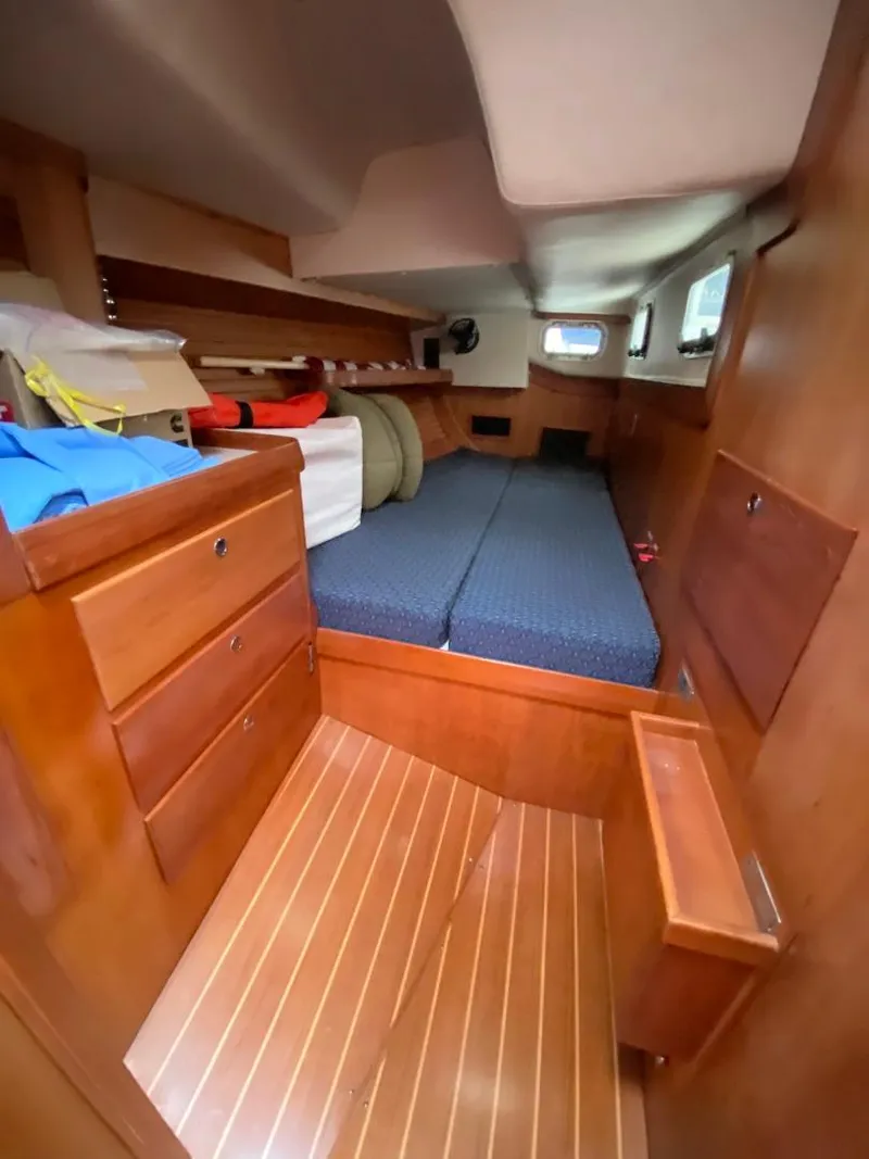 Slide: The Image of Interior of 2000 J Boats J/46 sailboat with wooden cabinetry and blue bedding. - 37