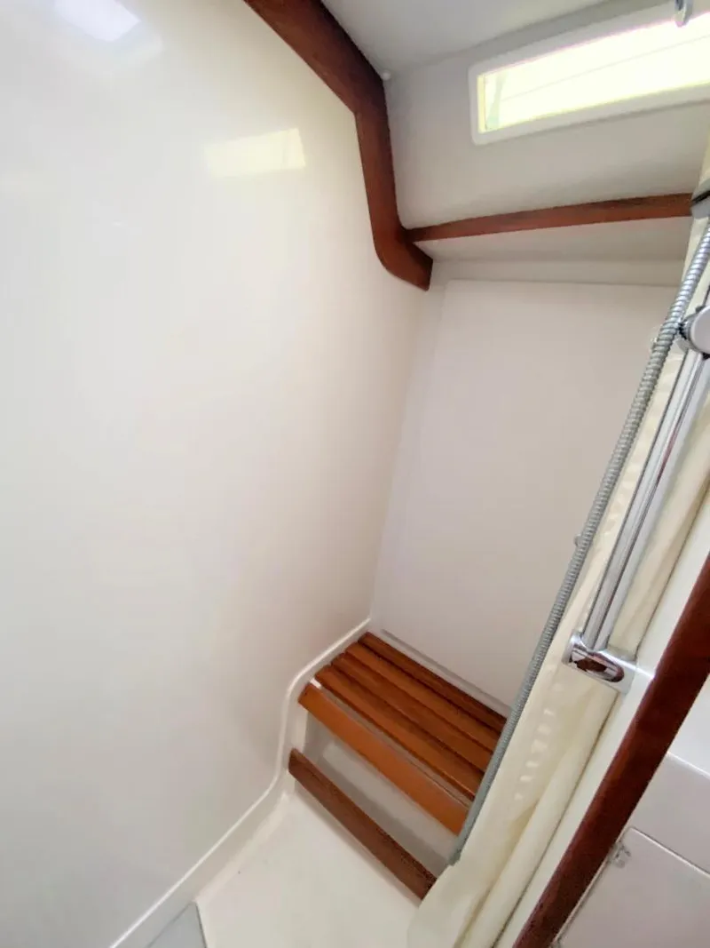 Slide: The Image of 2000 J Boats J/46 shower area with wooden bench and white walls. - 39