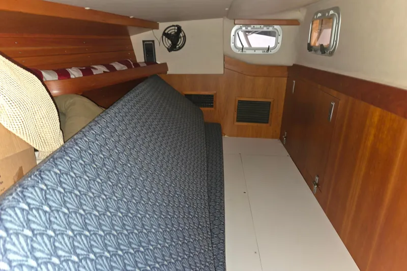 Slide: The Image of Interior cabin of 2000 J Boats J/46 sailboat with wooden paneling and blue upholstery. - 62