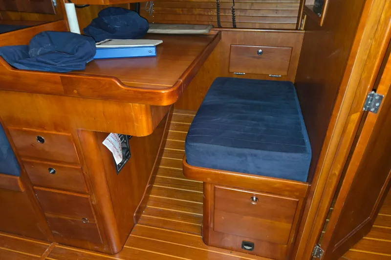 Slide: The Image of Interior of 2000 J Boats J/46 sailboat with wooden cabinetry and blue cushioned seating. - 69