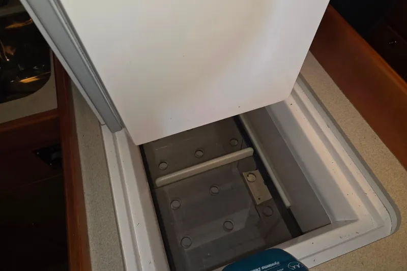Slide: The Image of Open storage compartment on 2000 J Boats J/46 sailboat, featuring a white lid and interior. - 71
