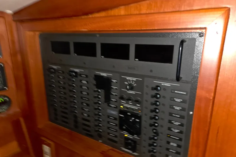Slide: The Image of Electrical panel on a 2000 J Boats J/46 sailboat, featuring various switches and controls. - 73