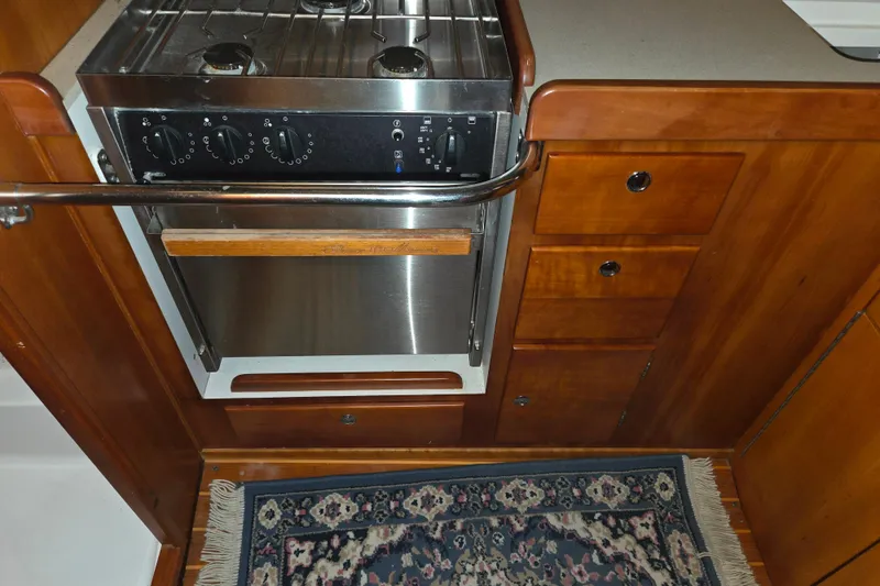 Slide: The Image of Galley kitchen in 2000 J Boats J/46 yacht with stove and wooden cabinetry. - 79