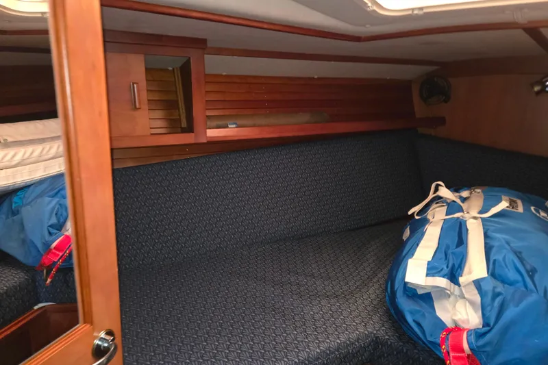 Slide: The Image of Interior cabin of 2000 J Boats J/46 sailboat with blue upholstery and wooden accents. - 81