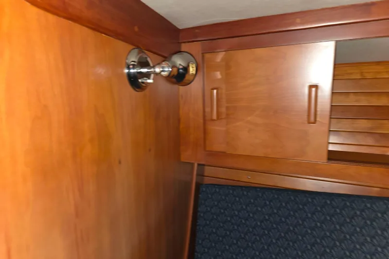 Slide: The Image of Interior of 2000 J Boats J/46, featuring wooden cabinetry and a wall-mounted light fixture. - 85