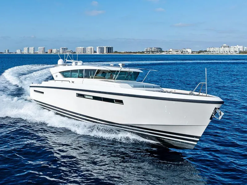 Slide: The Image of 2018 Delta Powerboats 54 IPS cruising on open water, cityscape in background. - 14