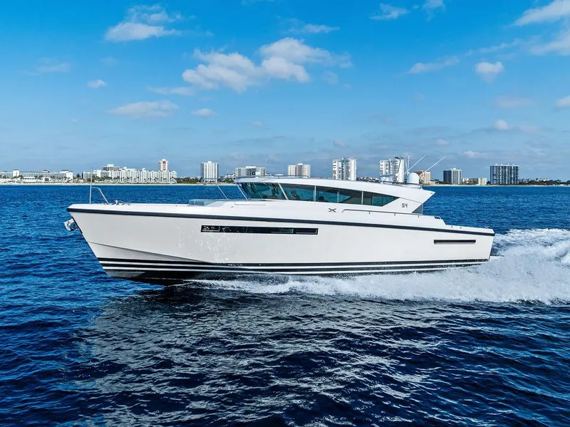 Slide: The Image of 2018 Delta Powerboats 54 IPS cruising on open water with city skyline in background. - 15