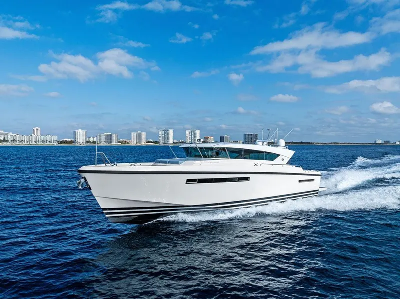 Slide: The Image of 2018 Delta Powerboats 54 IPS cruising on open water under a clear blue sky. - 16