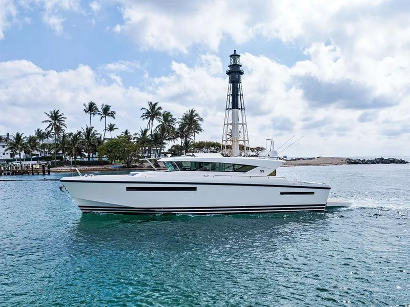 Slide: The Image of 2018 Delta Powerboats 54 IPS cruising near a lighthouse with palm trees in the background. - 20