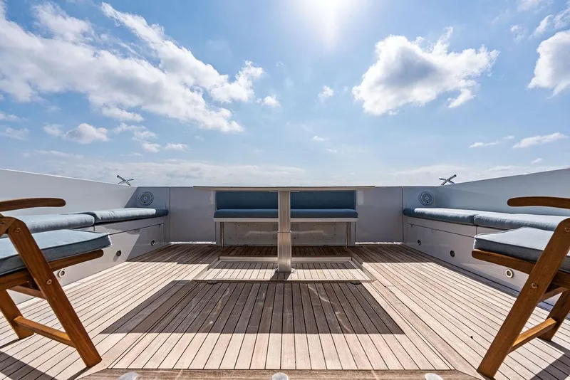 Slide: The Image of 2018 Delta Powerboats 54 IPS deck with seating, wooden flooring, and sunny sky. - 28