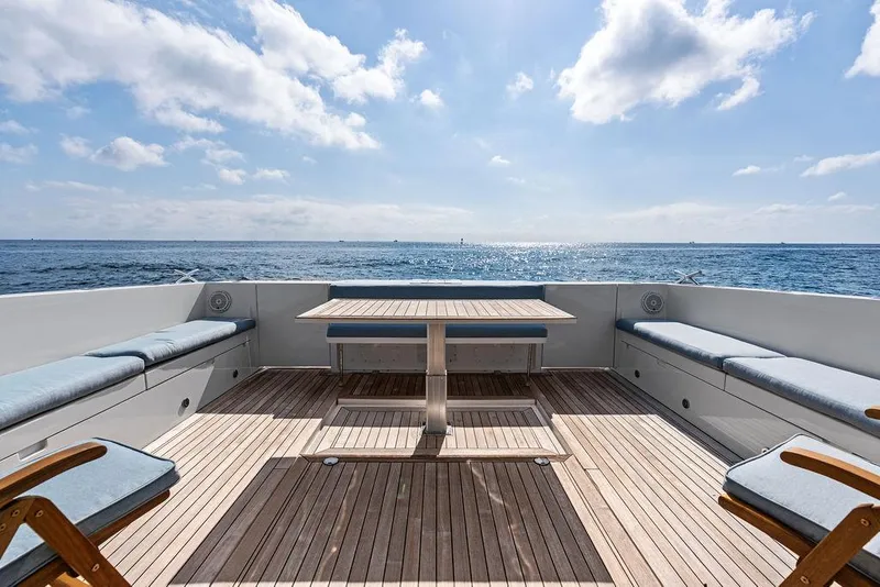 Slide: The Image of 2018 Delta Powerboats 54 IPS yacht deck with ocean view, featuring seating and a table. - 29