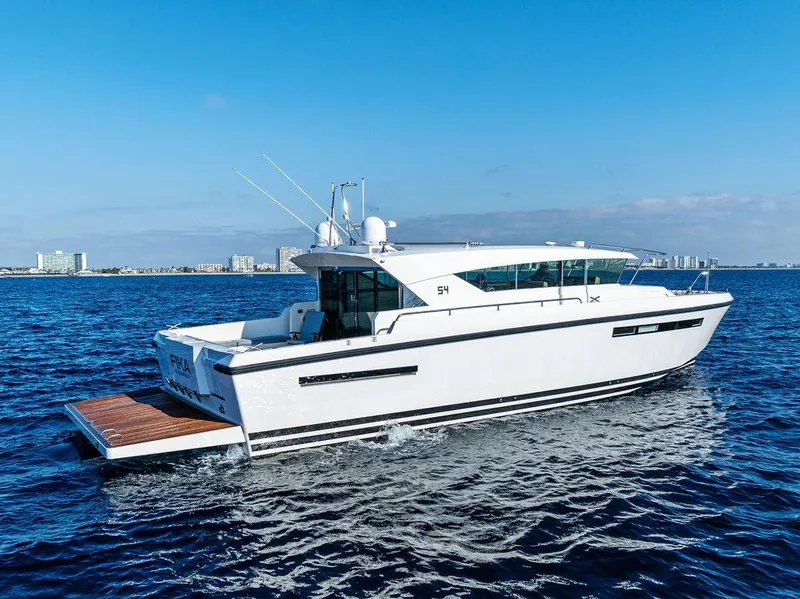 Slide: The Image of 2018 Delta Powerboats 54 IPS cruising on open water, city skyline in background. - 3