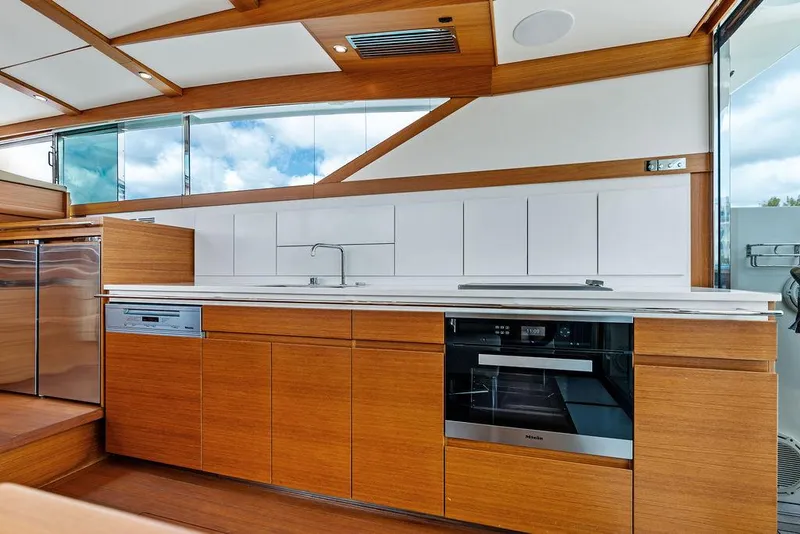Slide: The Image of Modern kitchen interior of 2018 Delta Powerboats 54 IPS with sleek wood cabinetry and appliances. - 41