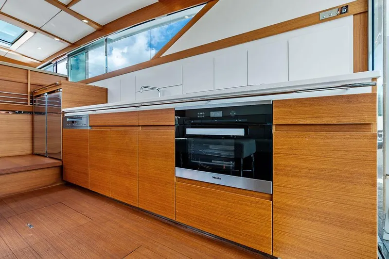 Slide: The Image of Modern kitchen interior on 2018 Delta Powerboats 54 IPS, featuring sleek wood cabinetry and appliances. - 42