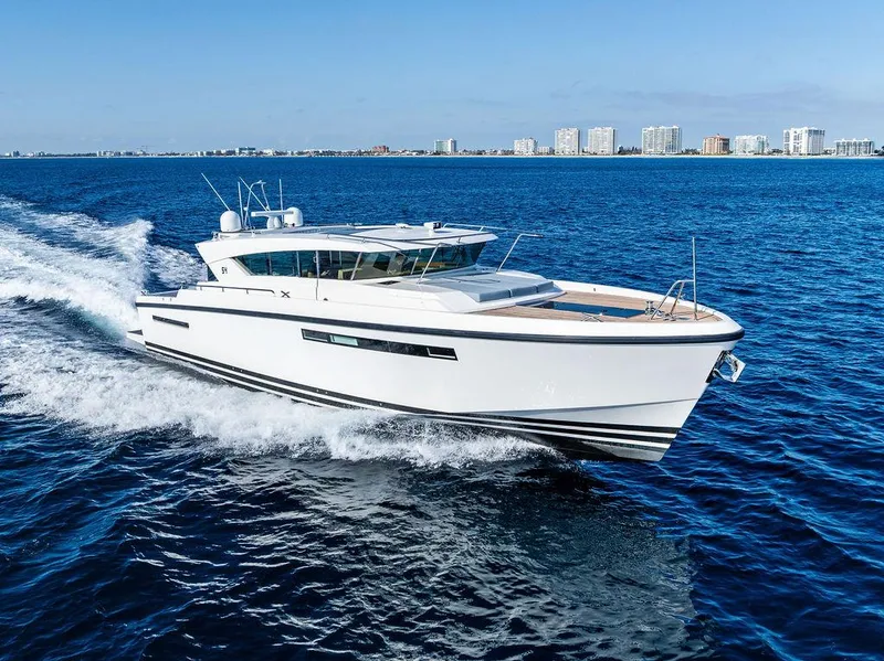 Slide: The Image of 2018 Delta Powerboats 54 IPS cruising on open water, city skyline in background. - 6