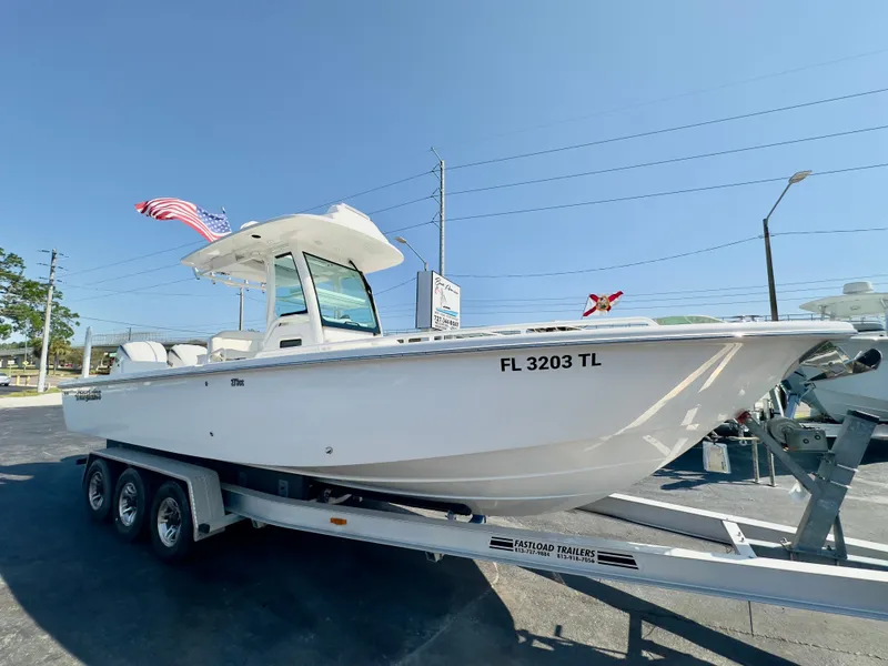 The Image of 2023 Everglades 273 Center Console boat on trailer, displayed outdoors under clear sky. - 1
