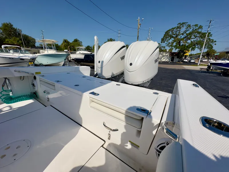 Slide: The Image of 2023 Everglades 273 Center Console boat with dual Yamaha engines in a marina setting. - 13