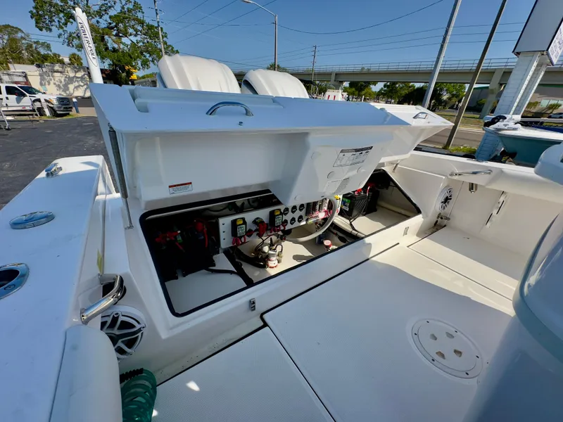 Slide: The Image of 2023 Everglades 273 Center Console boat with open electrical panel and seating area. - 17