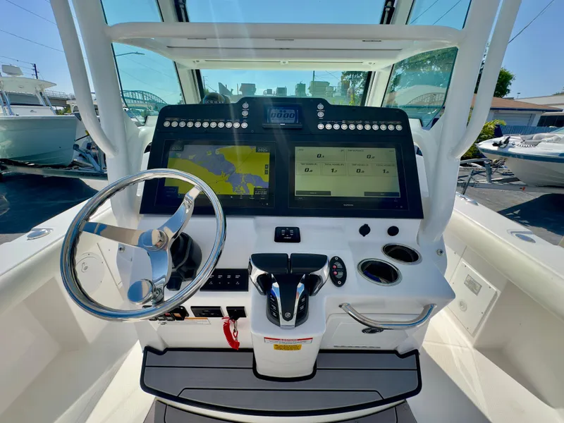 Slide: The Image of 2023 Everglades 273 Center Console boat dashboard with dual screens and steering wheel. - 23