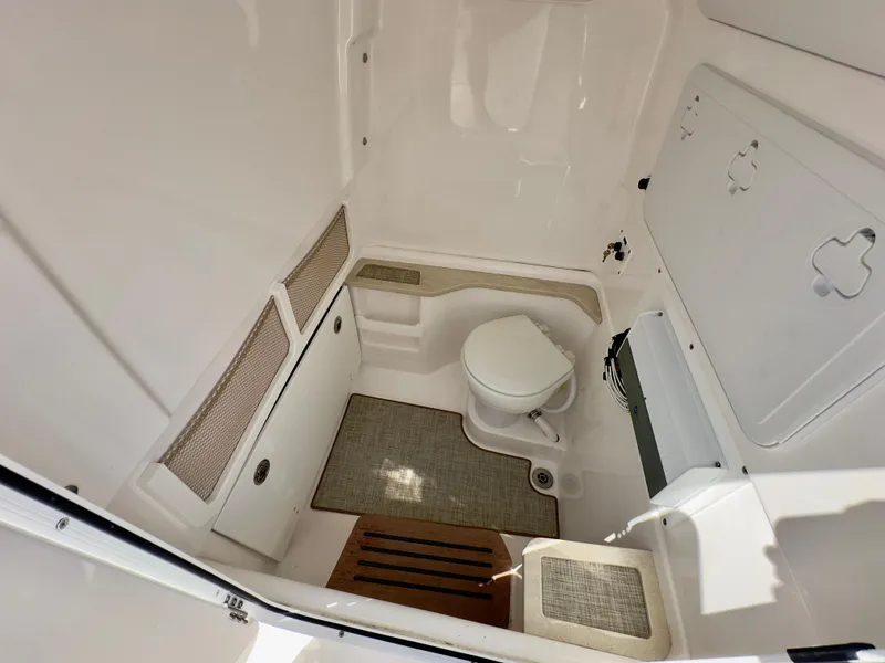 Slide: The Image of Interior of 2023 Everglades 273 Center Console boat, featuring a compact marine toilet. - 25