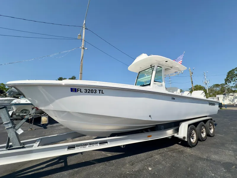 Slide: The Image of 2023 Everglades 273 Center Console boat on trailer, parked outdoors under clear blue sky. - 7