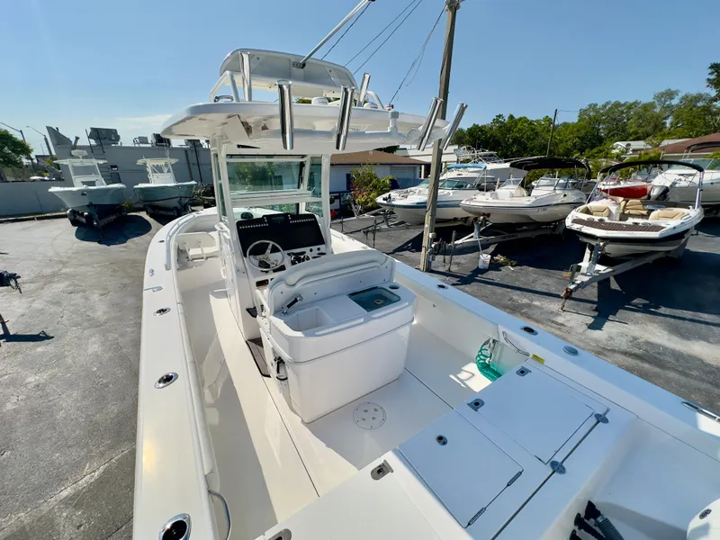 Slide: The Image of 2023 Everglades 273 Center Console boat in a marina, showcasing sleek design and spacious deck. - 9