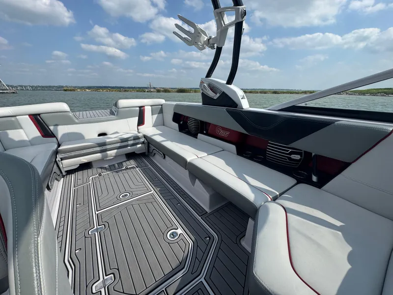 Slide: The Image of 2013 Nautique Super Air Nautique G25 interior with sleek seating and modern design on a sunny day. - 13