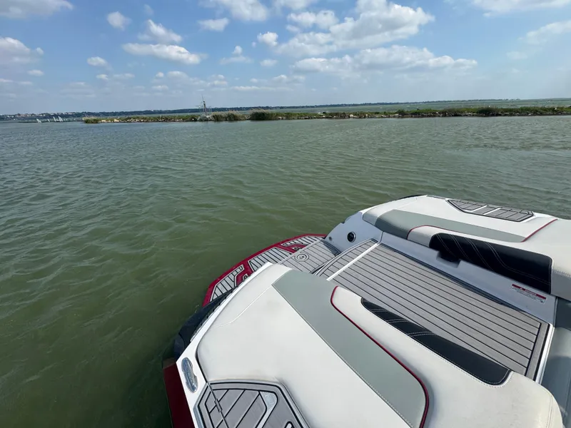Slide: The Image of 2013 Nautique Super Air Nautique G25 on calm water under a partly cloudy sky. - 17