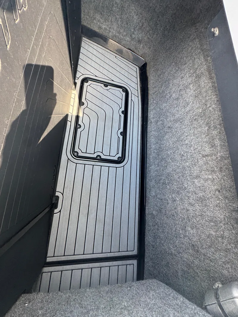 Slide: The Image of 2013 Nautique Super Air Nautique G25 storage compartment with carpeted interior and sleek design. - 19