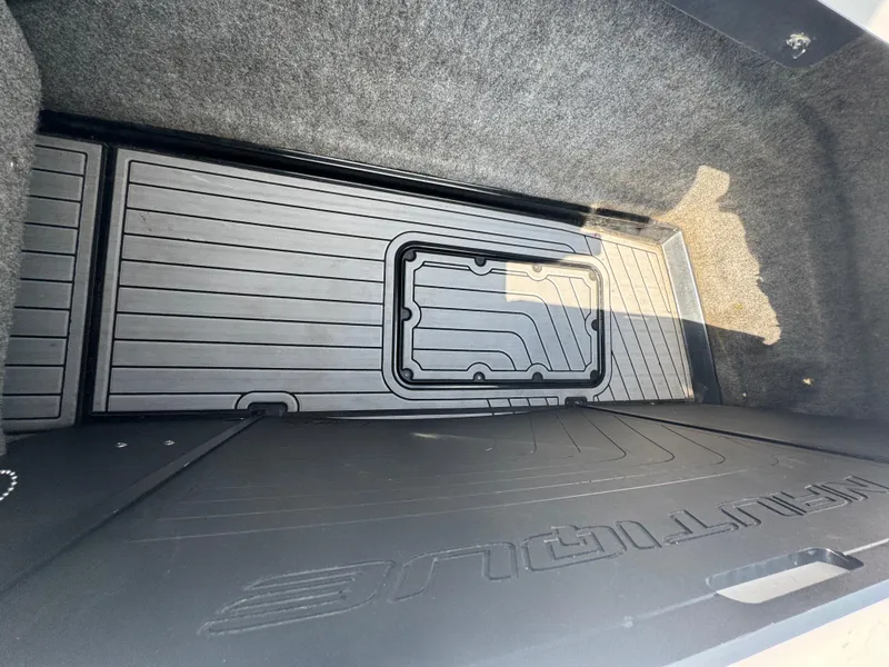 Slide: The Image of 2013 Nautique Super Air Nautique G25 storage compartment with textured flooring. - 20