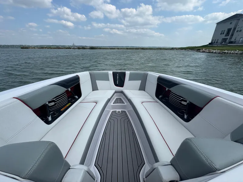 Slide: The Image of 2013 Nautique Super Air Nautique G25 boat interior with gray seating on a lake. - 6