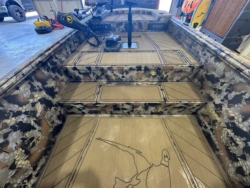 Slide: The Image of 2025 Thor TIMBER HAMMER boat interior with camouflage design and detailed flooring. - 12