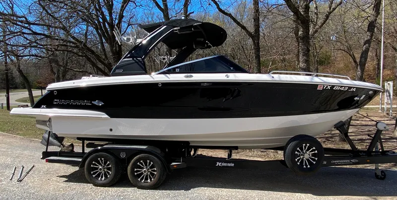 Slide: The Image of 2020 Chaparral 25 SURF boat on trailer, black and white design, parked outdoors. - 0