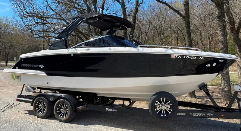 Slide: The Image of 2020 Chaparral 25 SURF boat on trailer, black and white design, parked outdoors. - 1